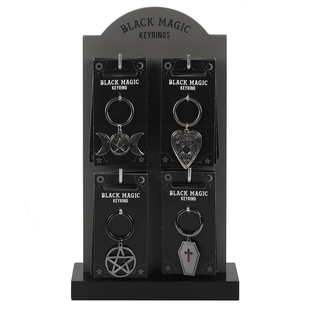 Black Magic keychains on a display stand with packaging.