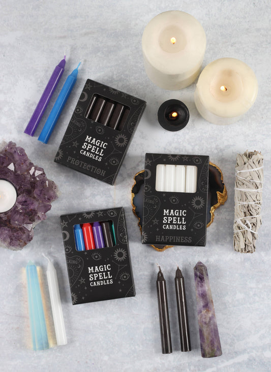 Collection of magic spell candles and related items on a textured surface