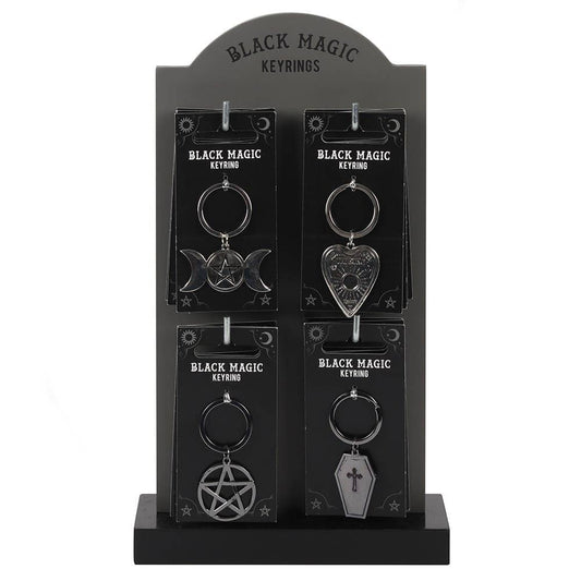 Black Magic keychains on a display stand with packaging.