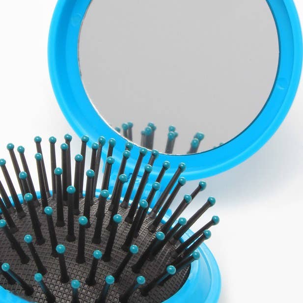 Blue hairbrush with black bristles on a white background