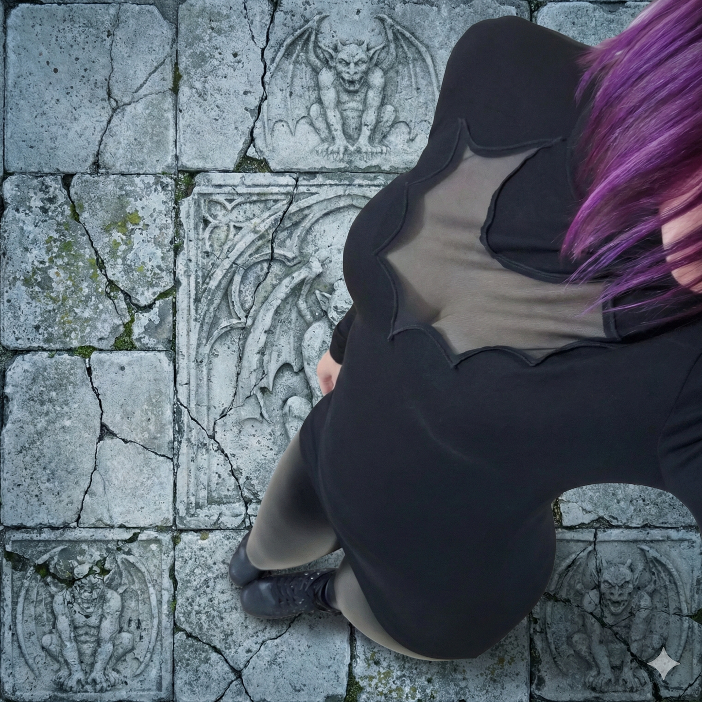 Person with purple hair sitting on stone pavement with decorative carvings.