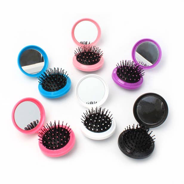 Set of small round mirrors with black bristle brushes on a white background